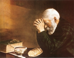Uomo che prega dinanzi al pane quotidiano