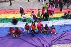 Bambini seduti su una grande bandiera della pace